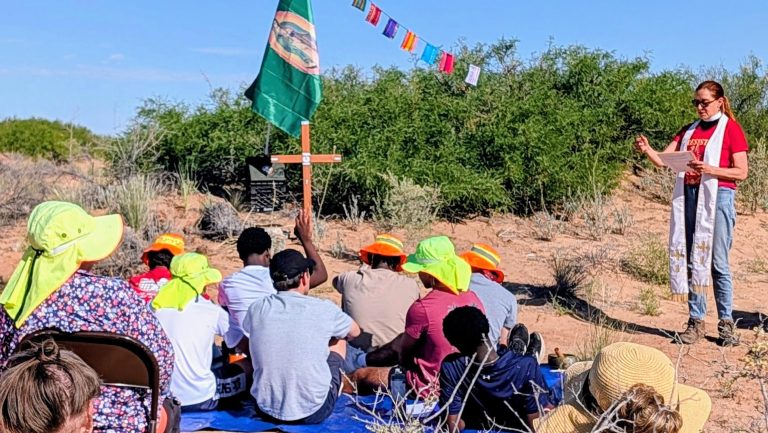 photo of people at multifaith service in New Mexico desert related to migrant deaths in desert